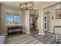 Inviting entryway with hardwood floors, a decorative chandelier, and large windows providing natural light at 5285 La Quinta Cir, Elizabeth, CO 80107