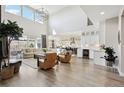 Airy and spacious living room featuring high ceilings and seamless flow into the kitchen area at 6361 Kenzie Cir, Castle Pines, CO 80108