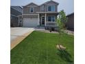 Charming two-story home featuring a covered front porch and a well-manicured lawn with a spacious two car garage at 2300 Mountain Sky Dr, Fort Lupton, CO 80621