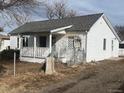 White house with a gray roof, front porch, and a small yard at 252 S Owens St, Byers, CO 80103