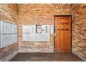 Interior mailboxes and secured door with wood trim within brick entryway at 1350 Josephine St # 307, Denver, CO 80206