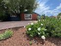 Well-maintained front yard boasting a mix of mulch, river rock, and blossoming white flowers at 10130 W 20Th Ave, Lakewood, CO 80215
