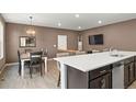 Open-concept living and dining area features modern lighting, stainless steel appliances, and a spacious breakfast bar at 11440 E 26Th Ave, Aurora, CO 80010