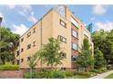 Multi-story brick apartment building with mature trees, garden, and landscaping at 10 N Ogden St # 5, Denver, CO 80218