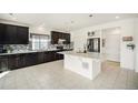 Modern kitchen features dark cabinets, granite countertops, tile backsplash, and island at 5325 Ventura St, Denver, CO 80249