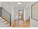 Bright foyer with hardwood floors, modern staircase, and a front door with vertical glass panels at 1407 Kennedy Ct, Boulder, CO 80303