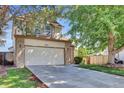 Two-story home with attached two car garage, mature landscaping, and manicured lawn at 15941 Bluebonnet Dr, Parker, CO 80134