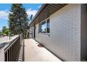 Side view of painted brick home showing updated windows and railing leading to front door at 9227 W 67Th Ave, Arvada, CO 80004