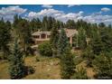 Exterior view of a home in a wooded setting, showcasing natural light and peaceful surroundings at 1682 Montane E Dr, Golden, CO 80401