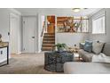 Cozy living room featuring plush carpeting, a staircase, and comfortable seating arrangements at 11950 E Exposition Ave, Aurora, CO 80012