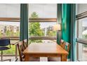 Bright dining area with hardwood floors, a wooden table, and large windows with neighborhood views at 2958 Syracuse St # 317, Denver, CO 80238