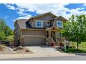 Charming two-story house with a two-car garage, stone accents, and a lovely front porch, creating a welcoming curb appeal at 2815 Dreamcatcher Loop, Castle Rock, CO 80109