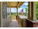 Inviting front porch with wood flooring, brick columns, and an American flag, offering a cozy outdoor space at 2815 Dreamcatcher Loop, Castle Rock, CO 80109
