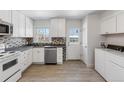 Updated kitchen with white cabinets, stainless steel appliances, and a stylish backsplash at 1570 Xanthia St, Denver, CO 80220