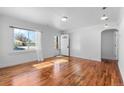 Empty living room featuring hardwood floors, natural light, and freshly painted walls at 1570 Xanthia St, Denver, CO 80220