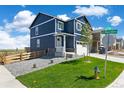 Charming two-story home featuring blue siding, white trim, and a well-manicured front lawn at 17959 Dandy Brush Ln, Parker, CO 80134