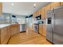 Spacious kitchen features stainless appliances, light wood cabinets, and hardwood floors at 275 Gold Maple St, Brighton, CO 80601