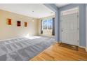Bright and airy living room with new carpet, large window, and hardwood entry, ready for personalization at 275 Gold Maple St, Brighton, CO 80601