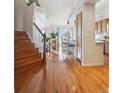 Hardwood floors, staircase, and view into the kitchen and living areas at 4806 Jericho Ct, Denver, CO 80249