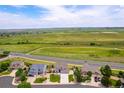 Aerial view of homes in a peaceful neighborhood, surrounded by picturesque green hills at 6950 Blue Mesa Ln, Littleton, CO 80125