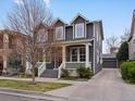 Two-story home featuring gray siding, white trim, and a detached two-car garage at 2880 Emporia Ct, Denver, CO 80238