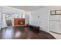 Bright living room with a cozy fireplace, sleek hardwood floors, and a view from the window at 17053 E Tennessee Dr # 212, Aurora, CO 80017