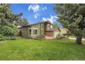 Beautifully landscaped yard surrounds this home with mature trees and lush green grass at 12671 W Dakota Dr, Lakewood, CO 80228