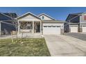 Beautiful house features a welcoming front porch and an attached two-car garage, perfect for a Gathering at 45871 Orchid Ave, Bennett, CO 80102