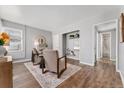 Living room with hardwood floors, built-in shelving, and a view of the bathroom at 1157 Krameria St, Denver, CO 80220