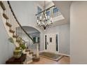 Bright foyer with a soaring ceiling, chandelier, staircase, and white front door with glass accents at 5426 S Jasper Way, Centennial, CO 80015