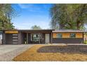 Charming home featuring a brick facade, wood accents, and a well-manicured front yard at 982 S Holly St, Denver, CO 80246