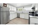 The kitchen features white cabinets, modern appliances, and wood-style flooring at 9175 Cole Dr, Arvada, CO 80004