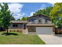 Charming two-story home with a well-maintained lawn and mature trees on a sunny day at 6775 Coors Ct, Arvada, CO 80004