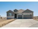 New construction home featuring stone and gray siding, a spacious driveway and a two-car garage at 13690 Emerald Lake St, Parker, CO 80138