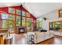 Bright living room featuring a fireplace, hardwood floors, and large windows with outdoor views at 960 Whispering Pines Ln, Breckenridge, CO 80424