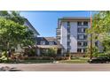 Exterior building view with well-maintained landscaping, brick accents, and tree lined street at 555 E 10Th Ave # 206, Denver, CO 80203