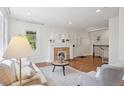 Bright living room featuring hardwood floors, fireplace, white walls, and a cozy seating arrangement at 1552 Hudson St, Denver, CO 80220