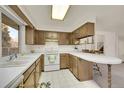 Functional kitchen featuring a breakfast bar, white countertops, and ample cabinet space at 8487 Yarrow Ct, Arvada, CO 80005