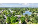 Aerial view of an estate home with mature trees and overlooking a scenic pond at 13 Buell Mansion Pkwy, Englewood, CO 80113