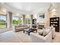 Elegant living room featuring a cozy fireplace, comfortable seating, and scenic outdoor views at 13 Buell Mansion Pkwy, Englewood, CO 80113