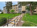 Building 207 with manicured landscaping, steps leading to the entrance, and multiple floors of residential units at 3022 S Wheeling Way # 109, Aurora, CO 80014