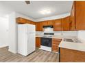 Cozy kitchen featuring wood cabinets, white appliances, and practical layout at 3022 S Wheeling Way # 109, Aurora, CO 80014