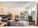 Sunlit living room featuring neutral walls, a patterned rug, and comfortable seating at 1830 Newland Ct # 109, Lakewood, CO 80214