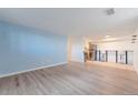 Open-concept living room with light wood floors and view of kitchen at 7335 E Quincy Ave # 104, Denver, CO 80237