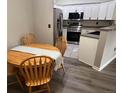 Cozy dining area adjacent to kitchen with wood table, chairs, and gray table runner at 7429 S Alkire St # 205, Littleton, CO 80127