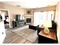 Bright living room with fireplace, sliding door to patio, wood-style flooring and a neutral color palette at 7429 S Alkire St # 205, Littleton, CO 80127