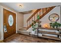 Inviting entryway with a stained glass door, wood staircase, and a stylish console table at 9336 Pierce St, Westminster, CO 80021