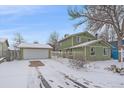 Two-story house with attached garage, snowy yard, and a green exterior at 9336 Pierce St, Westminster, CO 80021