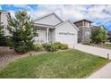 Well-maintained home showcasing a front yard, a two-car garage, and a covered porch with blue skies above at 26787 E Maple Ave, Aurora, CO 80018