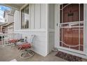 Inviting front porch with seating area, charming decor, and a view of the neighborhood at 26787 E Maple Ave, Aurora, CO 80018
